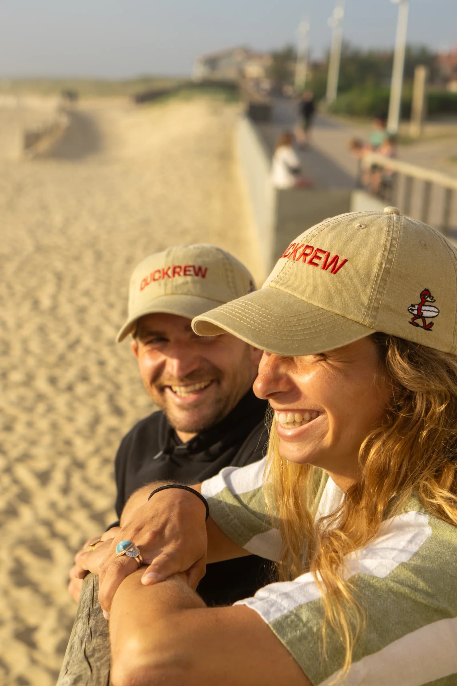 Couple portant LA DUCK CAP au coucher du soleil sur le ponton d'Hossegor